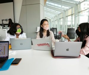 Three women work around a table.